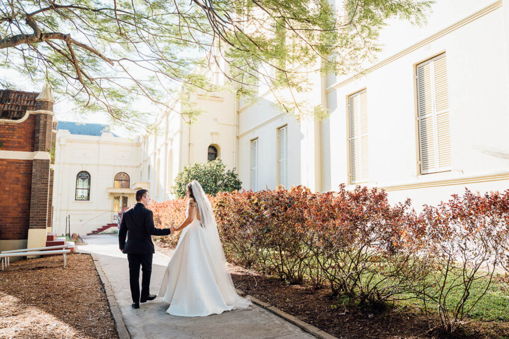 All Hallows Chapel Wedding - Bride & groom walking